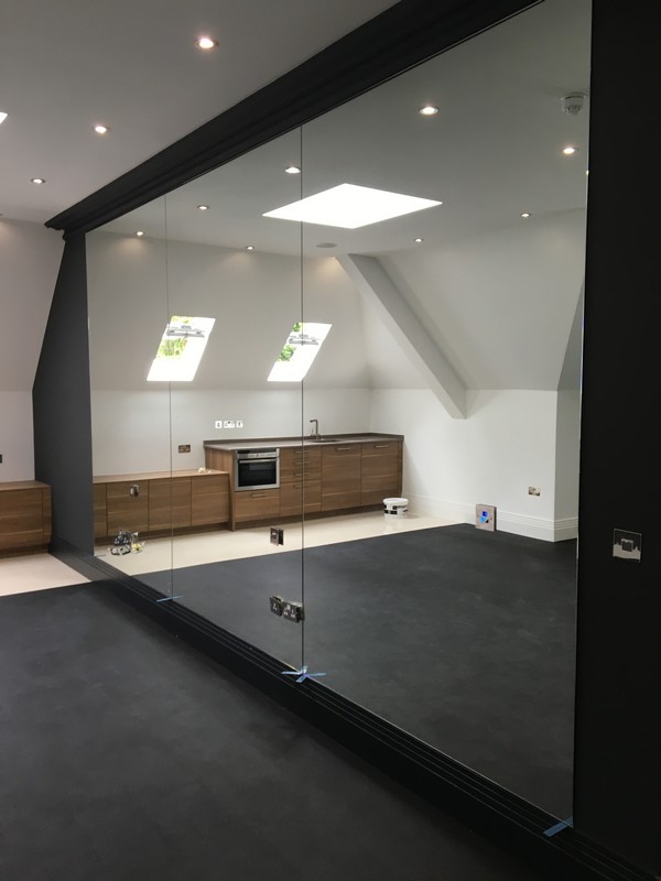 Frameless glass partition in loft conversion by Battersea glaziers